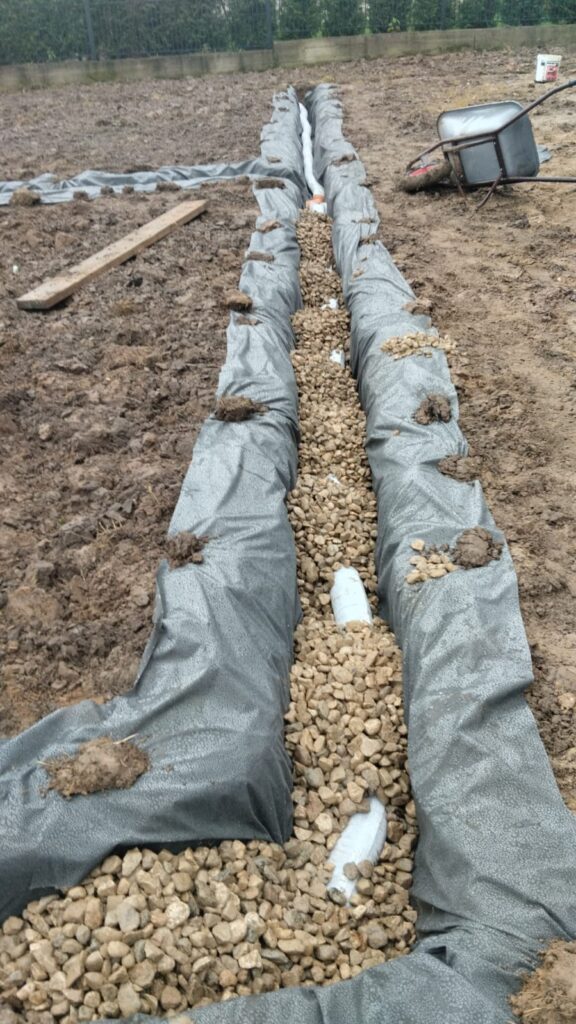 Filling the drainage ditches with the pipe with gravel