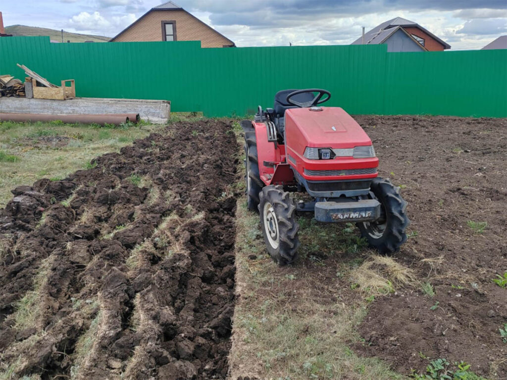 Tractor Yanmar con arado y arando el sitio.