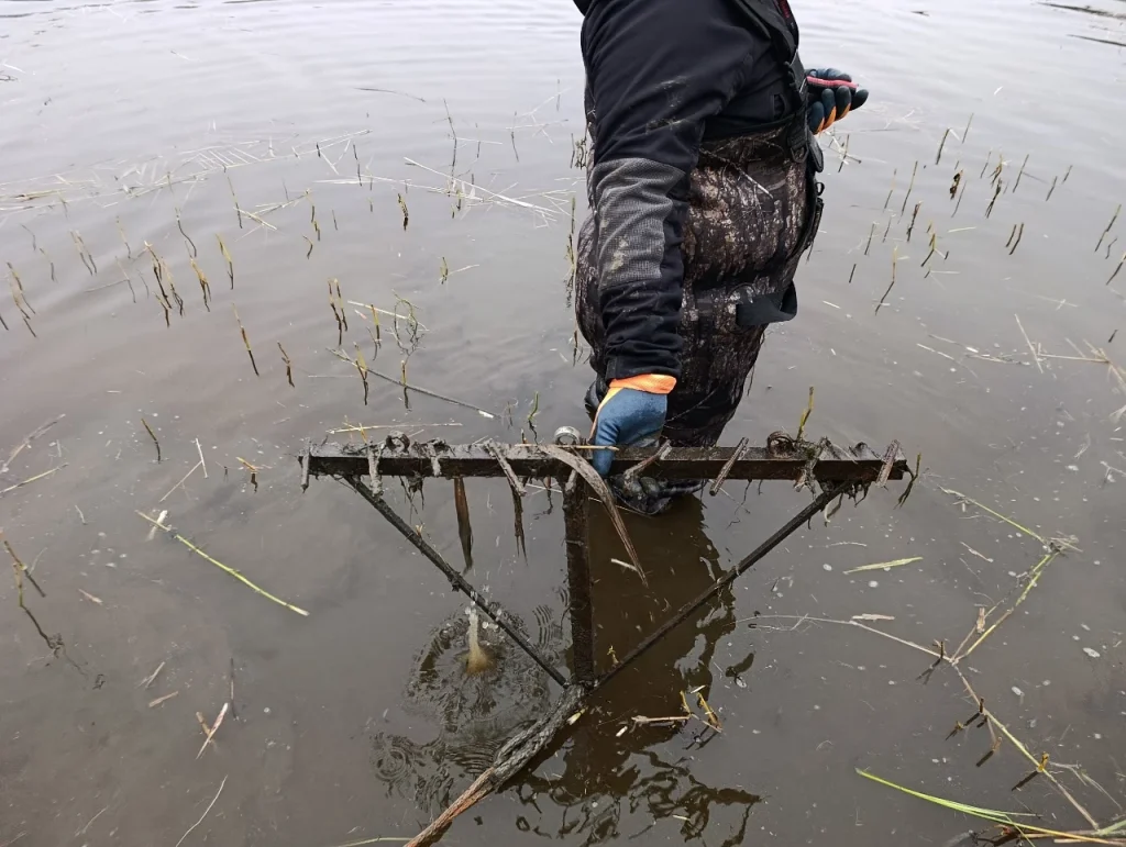 Un rastrillo de agua o una red de arrastre con cabrestante: limpieza del fondo de un embalse