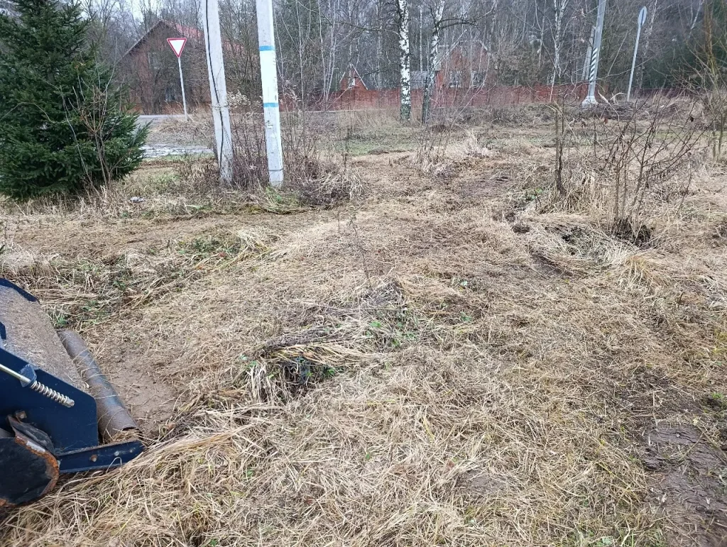 cut grass mixed with wet sand comes out from under the mulcher